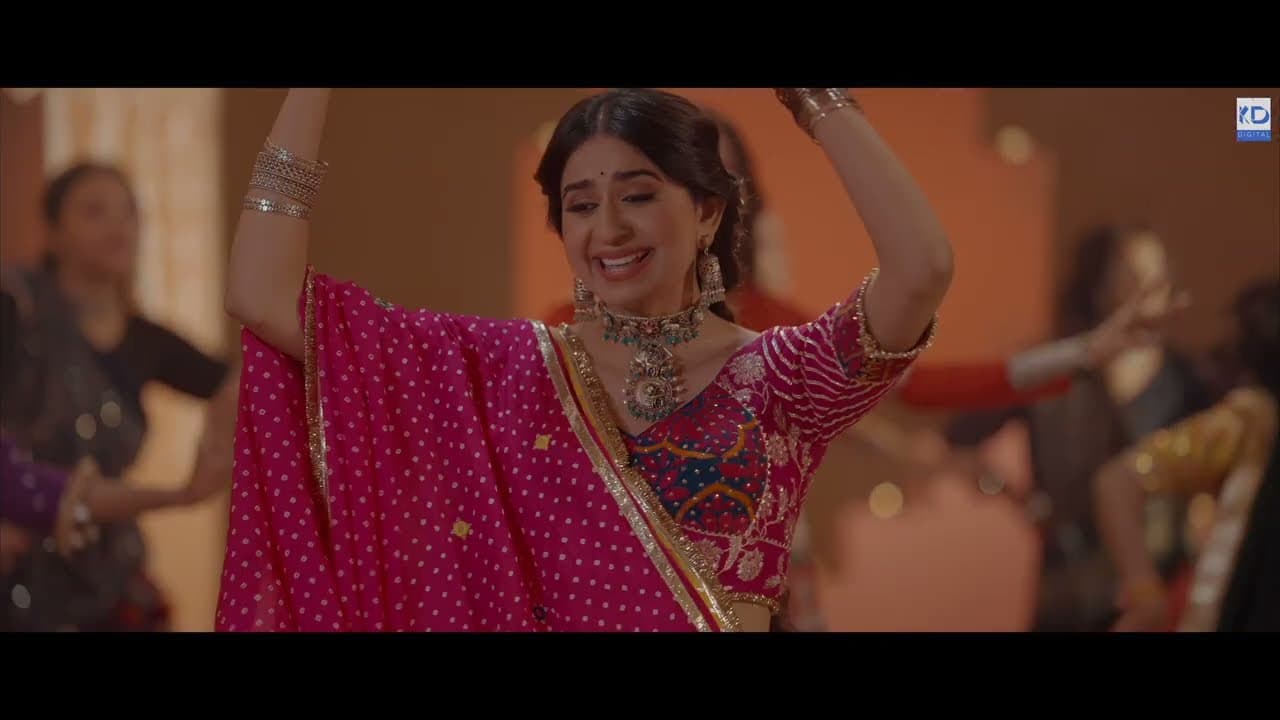 Kinjal Dave in a red chaniya choli mid-garba