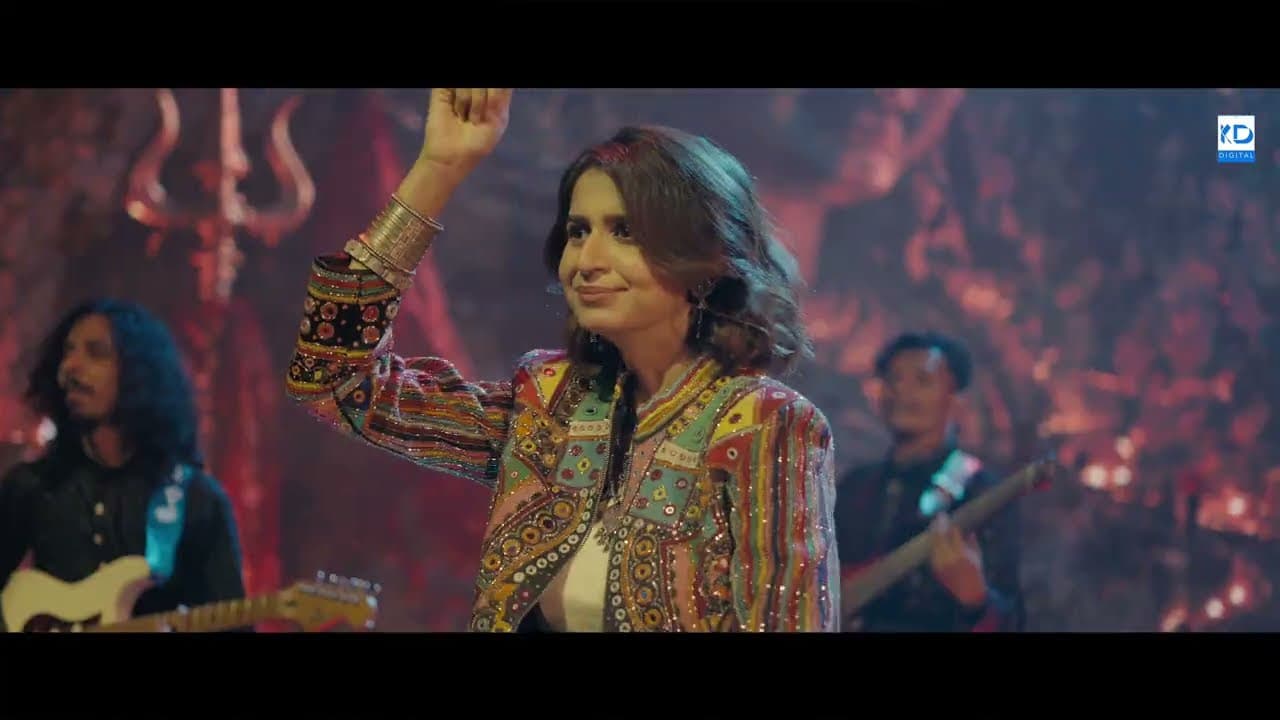 Kinjal Dave on stage with her band, arm raised